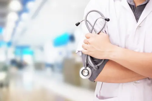 doctor-with-stethoscope-hands-hospital-background-768x512